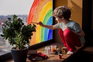 Child painting on window