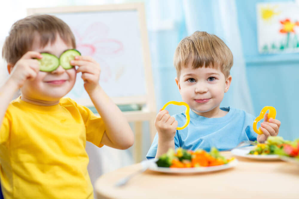 Kids smiling and eating veggies