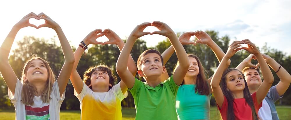 Group of kids forming hearts with their hands