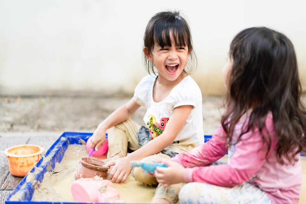Two children playing in a sandbox