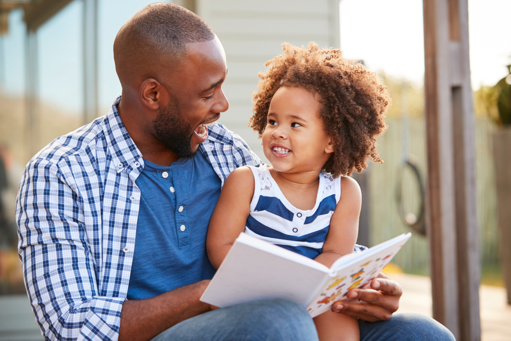 Dad and daughter reading books for children with autism