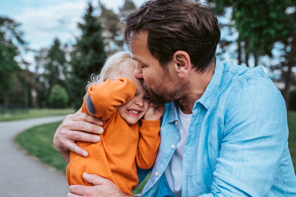 Father comforting a young son during a meltdown