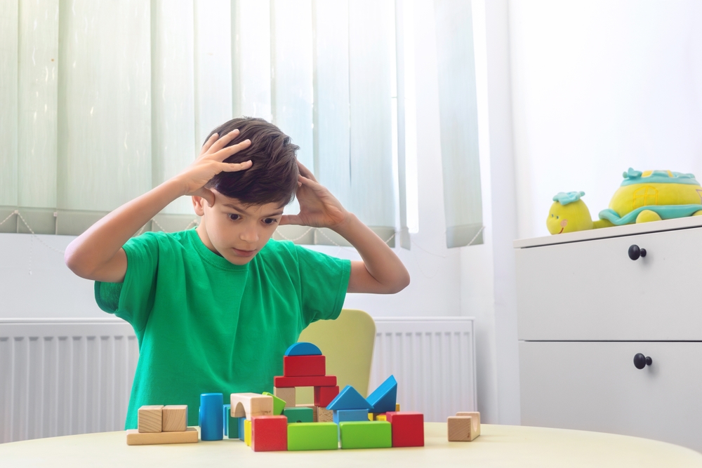 Overstimulated boy with autism playing with blocks
